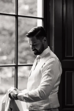 Timothy's getting ready moment voor het raam in zwart wit