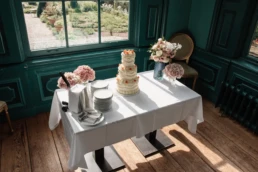 Linh & Timothy bruidstaart in Huize Frankendael op een nette klassieke tafel, in een donker turquoise wachtkamer
