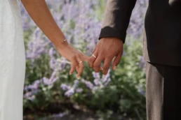 Mooi detail shot van het echtpaar dat de vingers vasthouden zodat de trouwring zichtbaar is